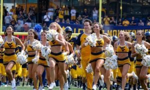 WVU cheerleaders running on the stadium pitch