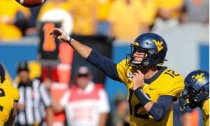 WVU football player throwing a ball
