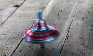 Spinning top toy on wooden floor.