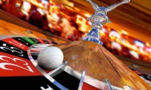 Close-up of roulette wheel and ball spinning in a vibrant casino setting