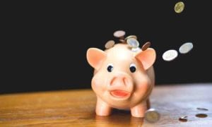 A piggy bank with coins flying around it