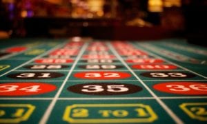 Close-up of a roulette betting layout in a casino with numbered red and black squares