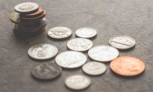Scattered coins and stacked change on a textured surface