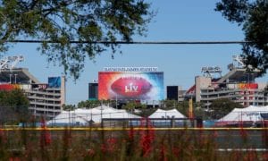 Raymond James Stadium exterior with Super Bowl signage and surrounding tents and foliage