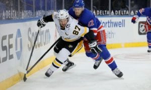 Two hockey players battling for the puck against the boards during an intense game