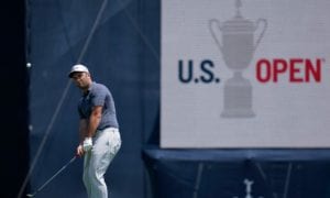 Jon Rahm, of Spain, chips onto the eighth green
