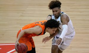 West Virginia's Miles McBride, right, tries to steal the ball from Oklahoma State's Cade Cunningham