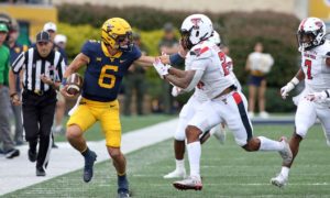 West Virginia quarterback Garrett Greene (6) is defended