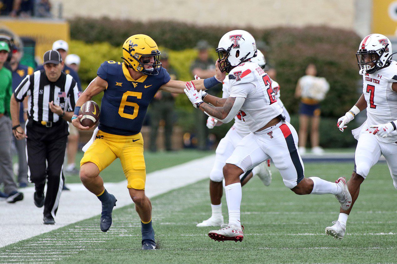 West Virginia quarterback Garrett Greene (6) is defended
