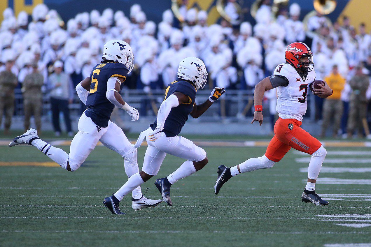 Oklahoma State quarterback Spencer Sanders (3) runs while defended by West Virginia linebacker
