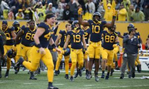 West Virginia players celebrate after a win against Iowa State in an NCAA college football game