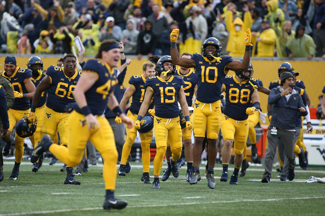 West Virginia players celebrate after a win against Iowa State in an NCAA college football game