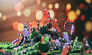 Colorful casino chips scattered and falling onto a green gaming table