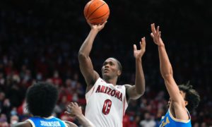 Arizona guard Bennedict Mathurin shoots between UCLA center Myles Johnson and guard Jules Bernard