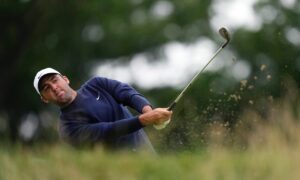 Scottie Scheffler watches his shot on the 11th hole